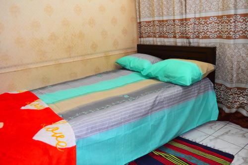 a bed with two pillows on it in a room at Kompass - Home Stay in Dhaka