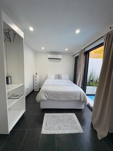 a bedroom with a bed and a large window at Coastal Beach Apartments in Maputo
