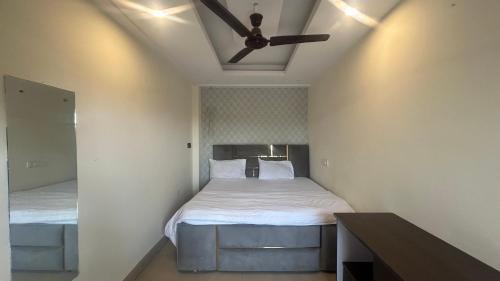 a bedroom with two beds and a ceiling fan at Jai Shree Hotel in Noida
