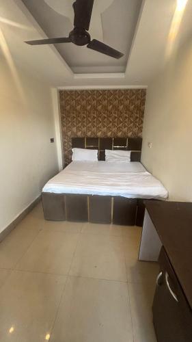 a bedroom with a bed with a ceiling fan at Jai Shree Hotel in Noida