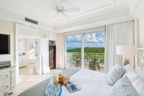 a living room with a white bed and a balcony at The Shore Club Turks & Caicos in Grace Bay