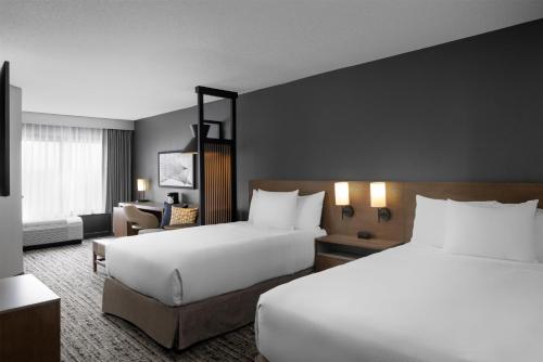a hotel room with two beds and a chair at Hyatt Place Atlanta/Cobb Galleria in Atlanta