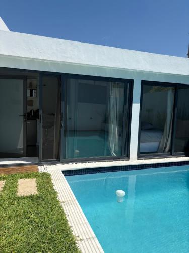 a house with a swimming pool with glass windows at Coastal Beach Apartments in Maputo