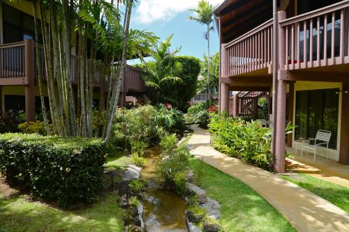a garden in front of a building with a pond at Club Wyndham Ka Eo Kai in Princeville