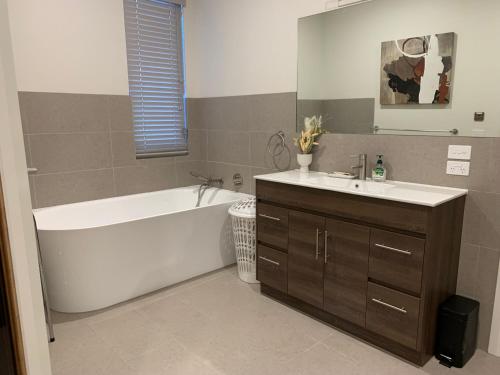 a bathroom with a white tub and a sink at Keystone in Dinner Plain