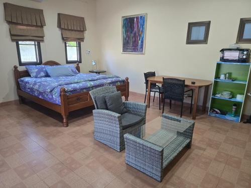 a bedroom with a bed and chairs and a table at Your space surrounded by Nature in Ban Mai Salae