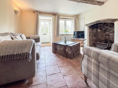 a living room with two couches and a fireplace at Rosemary Cottage in Mattishall