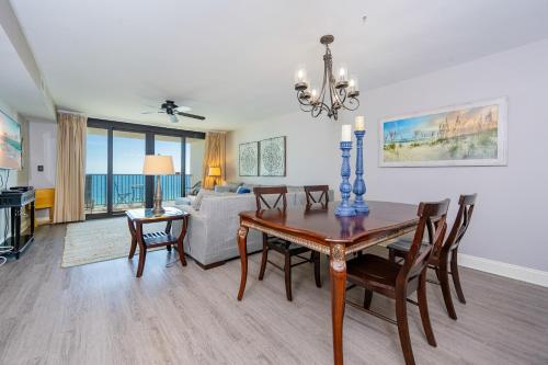 a dining room and living room with a table and chairs at Wind Drift 604S condo in Orange Beach