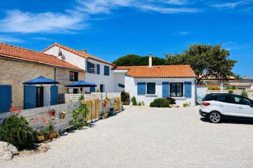 a white car parked in front of a house at Residence Clos des Aigrettes -Appartements a 30m du Port de La Cotiniere , Ile d Oleron -commerces et plages a pied in La Cotinière