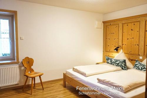 a small bedroom with a bed and a chair at Ferienwohnung Maxl in Schwangau