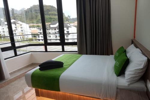 a bedroom with a bed with a large window at Cameron Green Inn Hotel in Brinchang