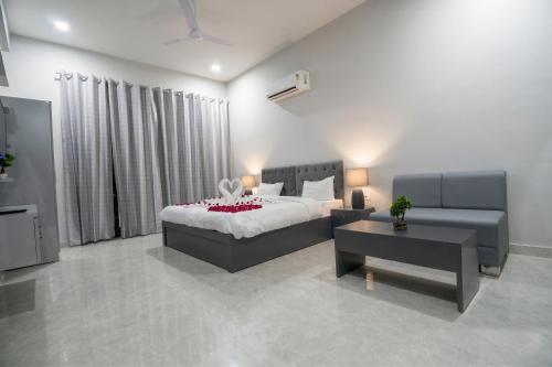 a bedroom with a bed and a couch and a table at The Stripes Ranthambore in Sawāi Mādhopur