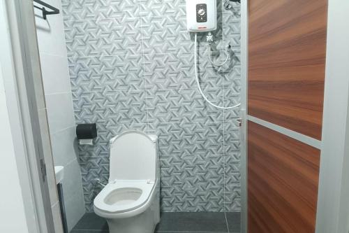 a small bathroom with a toilet in a stall at Cameron Green Inn Hotel in Brinchang