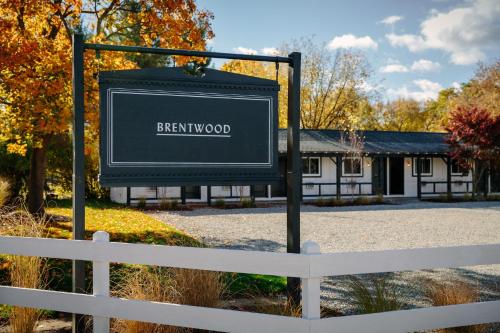 a sign in front of a fence in front of a building at Brentwood Hotel in Saratoga Springs