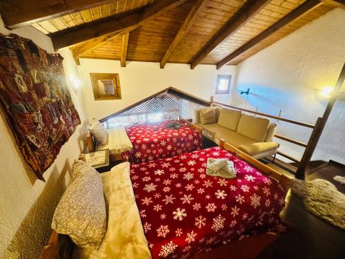 a bedroom with a red bed and a couch at CHALET MARIA livadi in Arachova