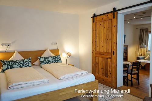 a bedroom with a bed and a wooden door at Ferienwohnung Mariandl in Schwangau