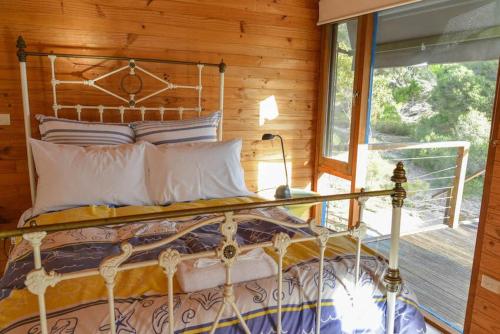 a bed in a room with a window at Georgina's place, Kangaroo Island in Brown Beach