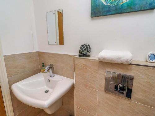 a bathroom with a sink and a mirror at Farne Cottage in Beadnell