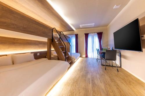 a hotel room with a bunk bed and a flat screen tv at Gouhou Garden Hotel Asakusa in Tokyo