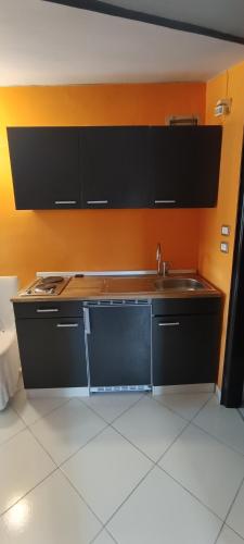 a kitchen with a sink and an orange wall at Chalet Nautilus in San Mango Piemonte