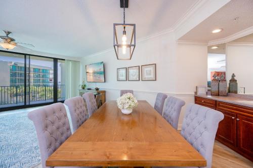 a dining room with a wooden table and chairs at Phoenix on the Bay 1309 in Orange Beach