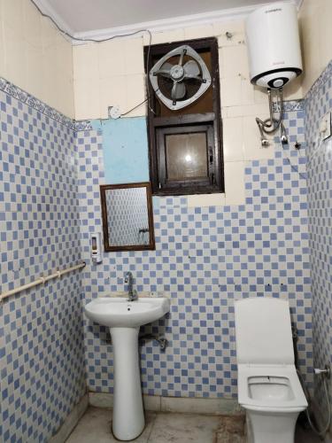 a bathroom with a sink and a toilet and a fan at Hotel Blue Heaven in Karnal