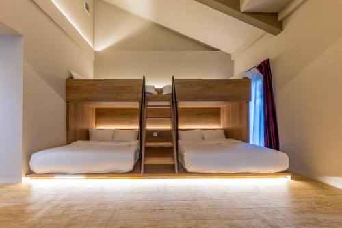 two bunk beds in a room with a window at Gouhou Garden Hotel Asakusa in Tokyo