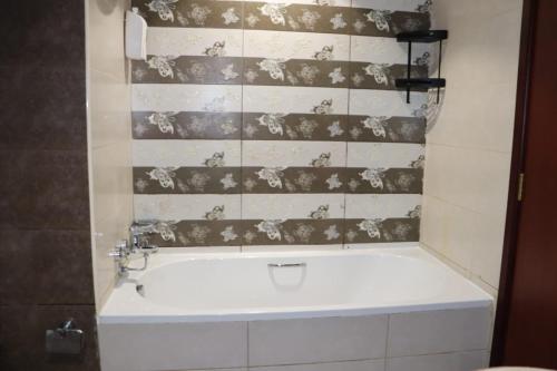 a bath tub in a bathroom with a tile wall at imperial homes 2 in Ajman 