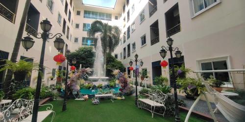 a courtyard with a fountain in the middle of a building at Napheera Royal Tel in Ban Khlong Bang Krathiam