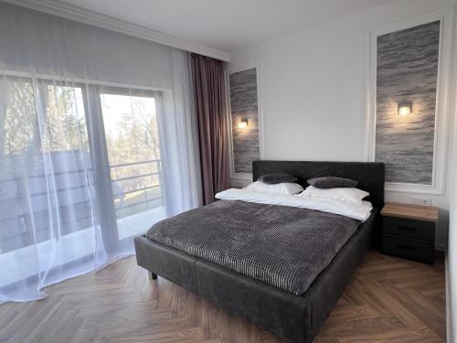 a bedroom with a large bed and a large window at Casa Cențiu II in Bran