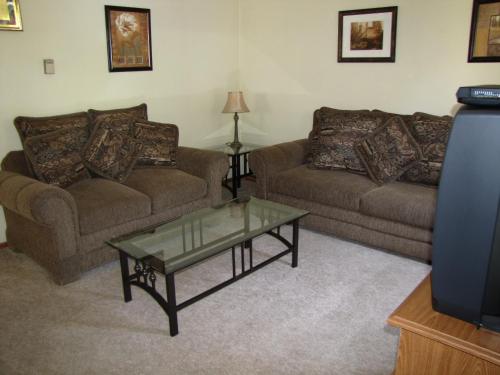 a living room with two couches and a glass coffee table at Kern Riverfront Lodge in Kernville