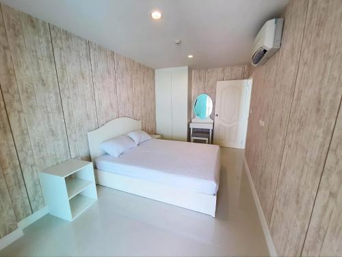 a small bedroom with a white bed and a table at 1 Bedroom Beachside Condo in Cha-am in Ban Bang Sai Yoi (1)