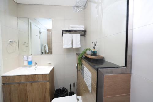 a bathroom with a sink and a toilet and a mirror at Premium 1BR on Al Maryah Island, near ADGM in Abu Dhabi
