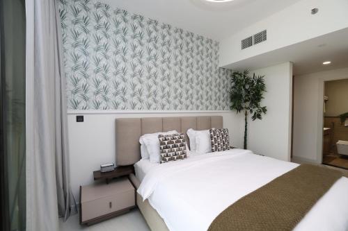 a bedroom with a large white bed and a wall at Premium 1BR on Al Maryah Island, near ADGM in Abu Dhabi