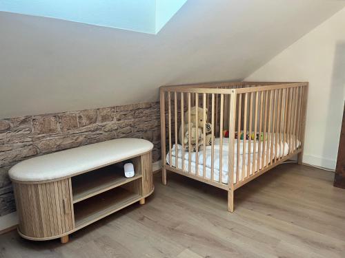 a nursery with a crib and a stool in a room at Sur les Toits de Honfleur in Honfleur