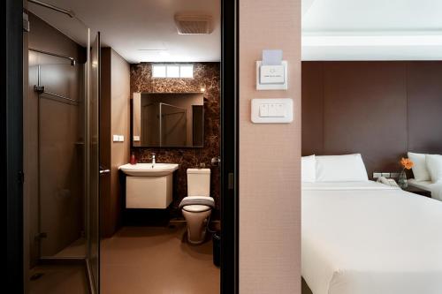 a small bathroom with a toilet and a sink at GLOW Pattaya in Pattaya South