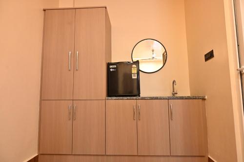 a kitchen with wooden cabinets and a sink and a mirror at Hotel Pinaka in Pratāpgarh