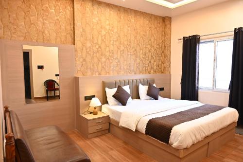 a bedroom with a large bed and a mirror at Hotel Pinaka in Pratāpgarh