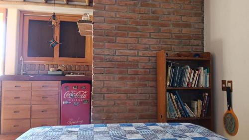 eine Ziegelwand in einem Zimmer mit einem Bett und einer Küche in der Unterkunft Estudio Leon in San Agustinillo