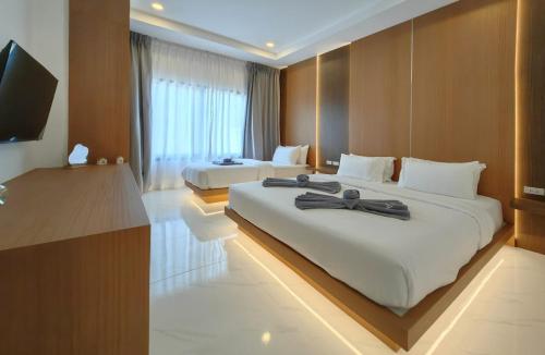 a hotel room with two beds and a flat screen tv at Samui Kozy Private Pool Villa in Nathon Bay