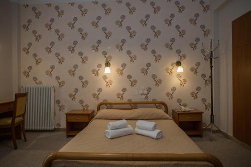 a bedroom with a bed with two towels on it at Hotel Liberty in Mesolongion