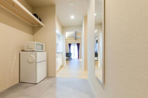 a kitchen with a refrigerator and a microwave at Gouhou Garden Hotel Asakusa in Tokyo