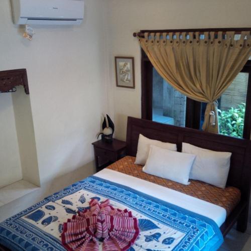 a bedroom with a bed with a rug on it at Nirvana Pension in Ubud