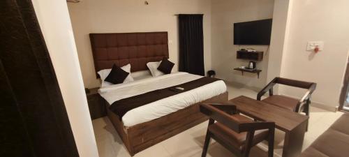 a bedroom with a bed and a table and a chair at HOTEL classic in Visakhapatnam