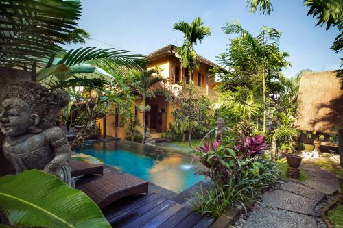 une villa avec une piscine dans un jardin dans l'établissement Gusde Tranquil Villas by EPS, à Ubud