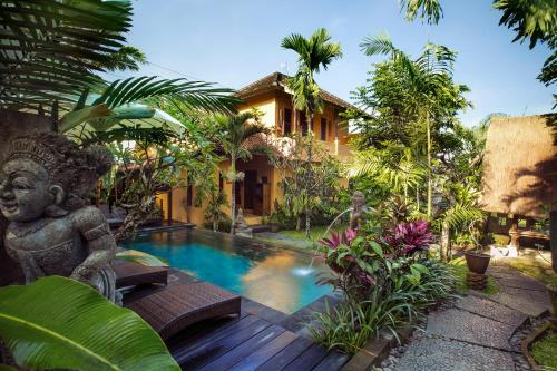 a villa with a swimming pool in a garden at Gusde Tranquil Villas by EPS in Ubud