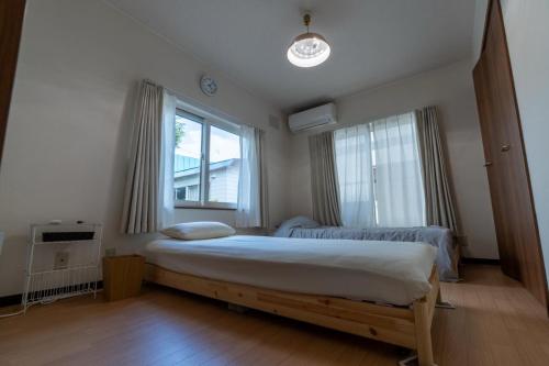 a bedroom with a large bed and a window at KitaのHikari in Sapporo