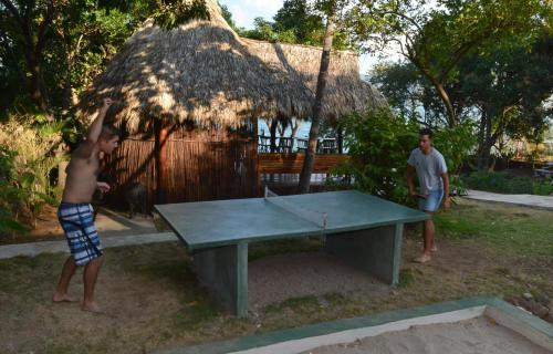 dos chicos jugando ping pong delante de una mesa de ping pong en Laguna Beach Club, en La Laguna