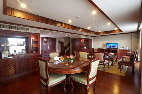 a dining room with a wooden table and chairs at Lao Plaza Hotel in Vientiane