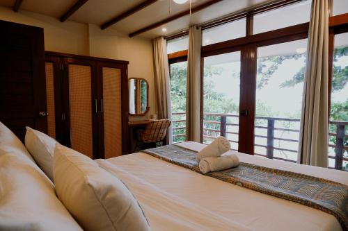 a bedroom with a bed with a teddy bear on it at Katig Beachfront Boutique Hotel in General Luna